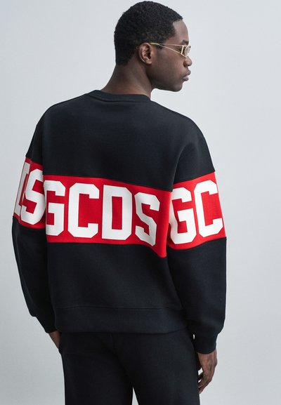 Felpa nera con una banda rossa caratterizzata da grandi lettere bianche "GC" e "DS", realizzata in tessuto morbido, con polsini a costine e design a girocollo.