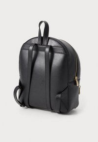 Zaino in pelle nera con forma arrotondata, due spallacci regolabili, una maniglia superiore e accessori in metallo dorato. Presenta tasche laterali.