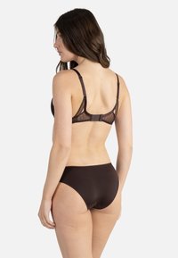 Soutien-gorge en dentelle marron et bikini taille haute assorti. Le soutien-gorge dispose de bretelles réglables et d'une fermeture à crochet, avec des détails transparents.