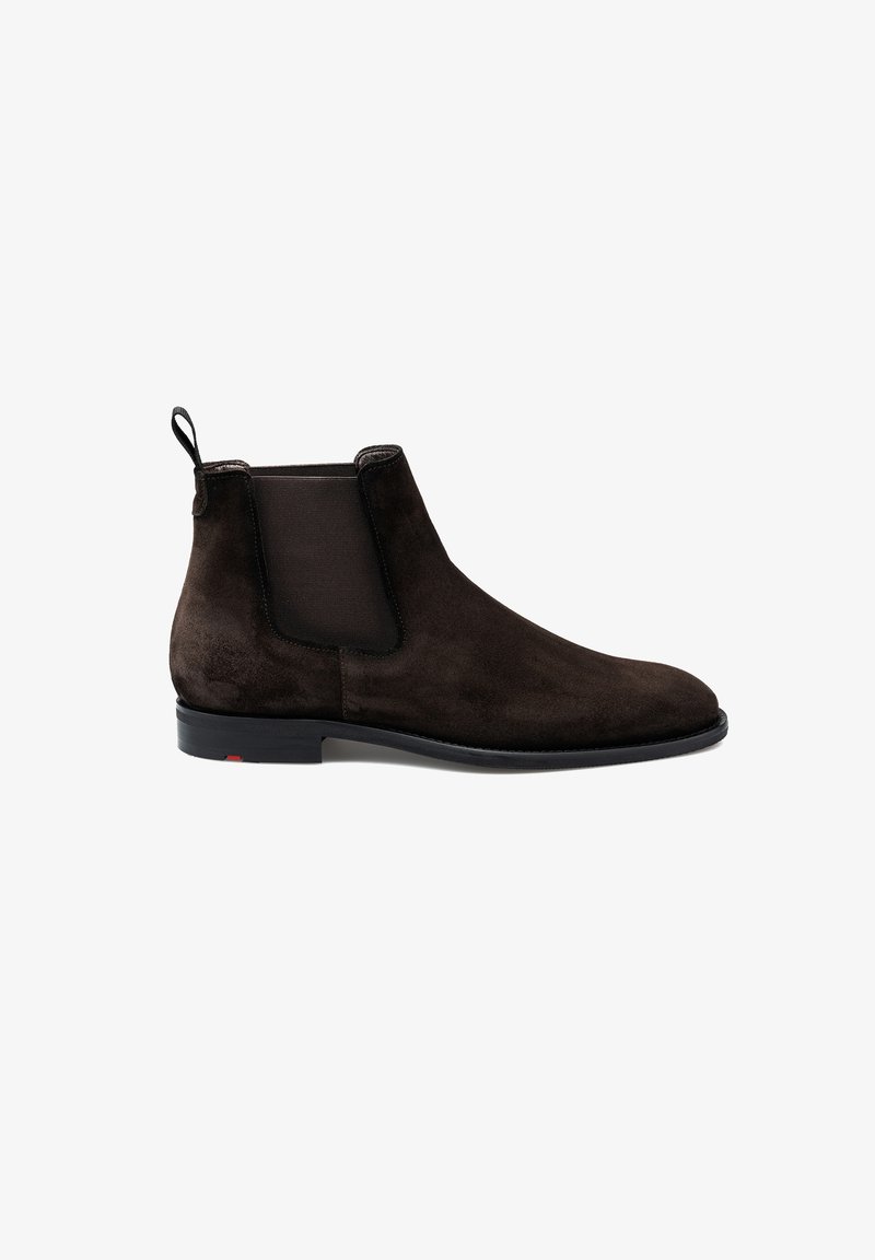Bottines Chelsea en daim marron avec panneaux latéraux élastiques, bout rond et petite languette à l'arrière ; semelle noire avec un accent rouge.