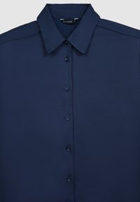 Camicia blu navy realizzata in tessuto liscio, con colletto a punta, placket centrale con bottoni e sei bottoni coordinati.