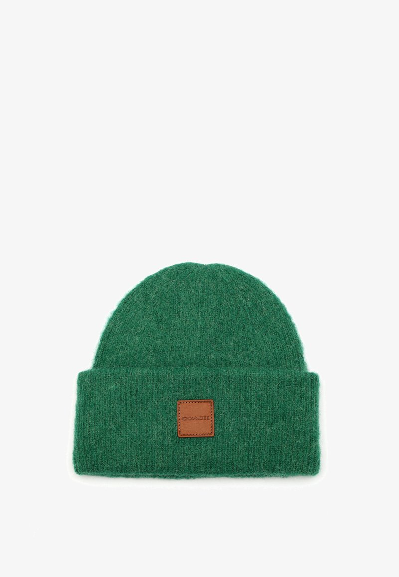 Green knitted beanie hat with a folded cuff, made of soft wool. Features a square leather patch with embossed logo.