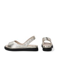 Metallisch silberne Slingback-Sandalen mit offenem Zehenbereich und flacher schwarzer Sohle. Strukturiertes Obermaterial und glattes Innenfutter für mehr Komfort.
