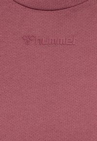 Rosa t-shirt i en texturerad, ribbad tyg. Har en subtil präglad logotyp på bröstet i en matchande ton.