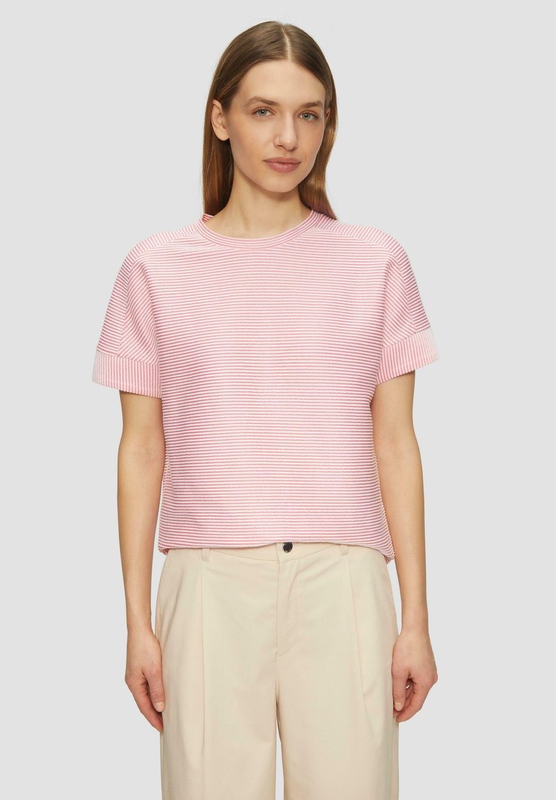 Gestreiftes, kurzärmliges Oberteil in hellrosa und weiß, mit rundem Halsausschnitt und lockerer Passform, kombiniert mit beigen Hosen.