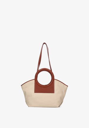 Sac à main en toile beige avec des poignées circulaires en cuir marron et une longue bandoulière, forme trapézoïdale structurée.