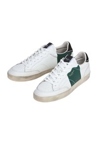 White leather sneakers with green and black accents, perforated detailing on the toe, flat laces, and a low-profile rubber sole.