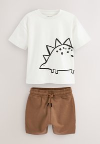 Chemise blanche à manches courtes avec motif dinosaure noir, associée à un short marron à taille élastique avec cordon.