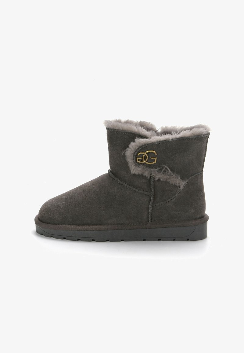 Graue Wildleder-Stiefeletten mit einem flauschigen grauen Futter, die ein goldfarbenes Logo-Detail an der Seite und eine flache schwarze Gummisohle aufweisen.