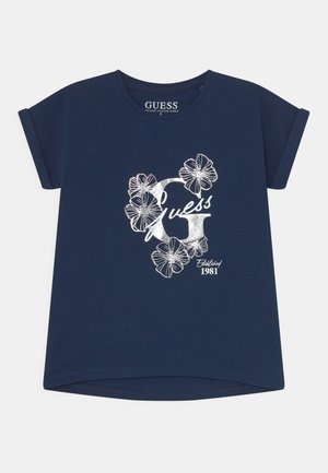 Marineblaues Baumwoll-T-Shirt mit umgeschlagenen kurzen Ärmeln, mit einem weißen Blumendesign und dem Schriftzug "Guess" sowie "Established 1981" darunter.