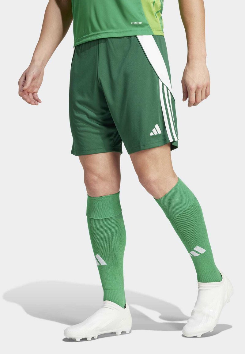 Green soccer shorts with white stripes and logo, paired with matching green socks and white cleats, featuring a smooth, athletic fabric.