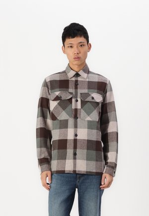Brown and gray plaid button-down shirt with two chest pockets, lightweight wool material, and a collar. Worn with blue jeans.
