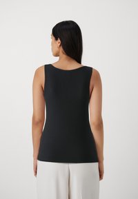 Top a canottiera nera a coste con scollatura rotonda e design senza maniche, che mette in risalto una silhouette aderente e una texture liscia.