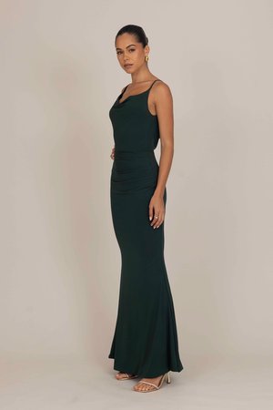 Rochie conică de culoare verde închis, cu un guler plisat, bretele subțiri și un tiv evazat. Material neted și detalii minime, având o siluetă elegantă.