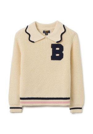 Pull en tricot crème avec un col à vagues bleu marine, une patch en feutre en forme de "B" et un ourlet rayé bleu marine et rose. Tissu texturé avec des poignets côtelés.