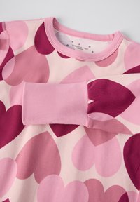 Rosa Sweatshirt mit einem Herzmuster in verschiedenen Schattierungen von Rosa und Burgunder. Gerippter Halsausschnitt und Bündchen, weiche Baumwolltextur.