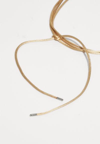 Lacci in oro metallizzato con una finitura lucida, dotati di estremità in metallo su entrambi i lati. La texture è liscia e leggermente lucida.