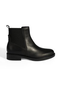 Bottines Chelsea en cuir noir avec panneaux élastiques sur les côtés, tirette à l'arrière, petit talon empilé et bout rond sur fond blanc.
