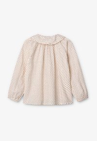 Blusa a maniche lunghe in tessuto bianco sporco, con scollatura arricciata e piccoli motivi floreali rossi e blu distribuiti su tutta la superficie.