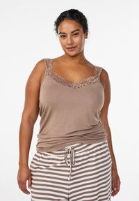 Braunes Tanktop mit Spitzenbesatz entlang des Halsausschnitts, kombiniert mit gestreiften Pyjamahosen. Der Stoff wirkt weich und locker geschnitten.