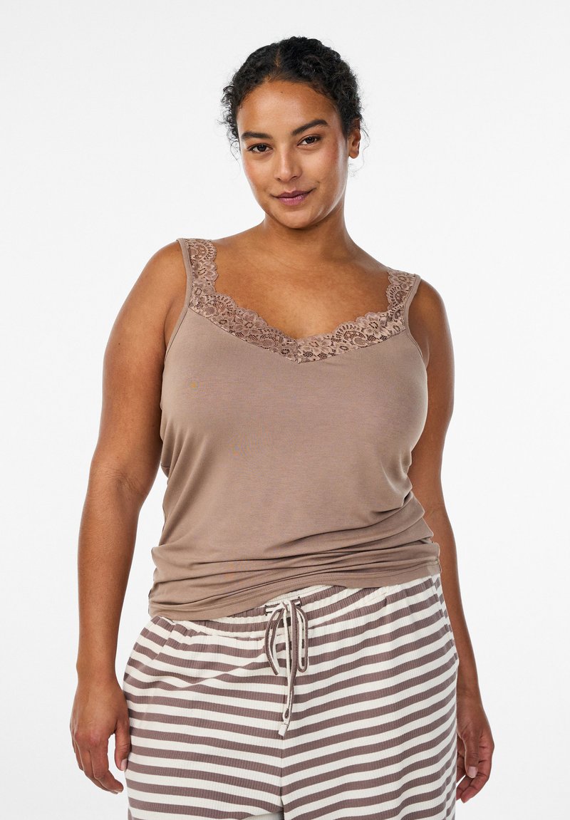 Braunes Tanktop mit Spitzenbesatz entlang des Halsausschnitts, kombiniert mit gestreiften Pyjamahosen. Der Stoff wirkt weich und locker geschnitten.
