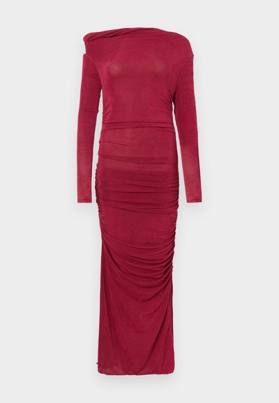 Garas piedurknes pieguloša bordo krāsas kleita ar savilkumiem un asimetrisku kakla izgriezumu uz vienkārša balta fona.