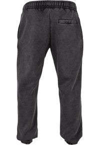 Sorte sweatpants med elastisk talje, sidelommer og en enkelt baglomme. Blødt materiale med en glat tekstur.