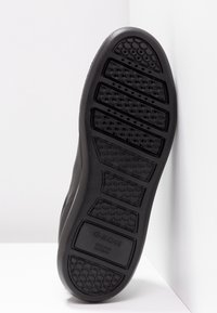 Semelle de chaussure noire avec motifs de bande de roulement hexagonaux et rainures rectangulaires, portant le nom de la marque "GEOX" et la mention "Italian Patent" en relief.
