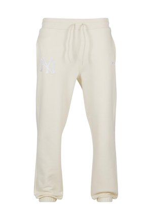 Pantalones de chándal color crema, hechos de una tela suave, con una cintura elástica ajustable y puños acanalados. Logo decorativo de NY en un lado.