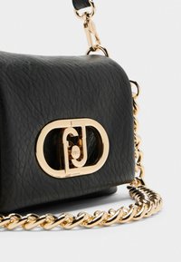 Borsa a tracolla nera in pelle con superficie texturizzata, un prominente clasp con logo dorato e una tracolla in catena dorata. Forma quadrata compatta.