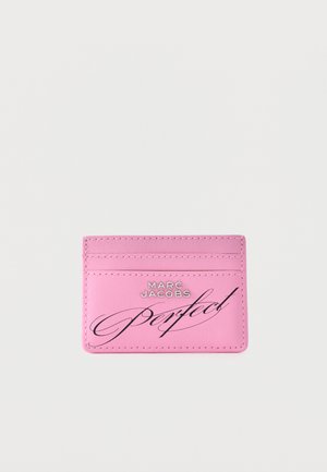 Porte-cartes rose avec trois emplacements pour cartes, bords cousus et « Marc Jacobs Perfect » imprimé sur le devant en lettres argentées et noires.