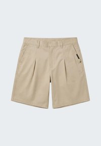 Shorts beige ajustés avec plis avant, poches latérales, passants pour ceinture et une petite étiquette en tissu noir sur la poche droite.