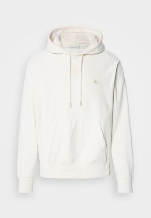 Helle Creme Kapuzenpullover mit Fronttasche, Kordelzugkapuze und gesticktem Logo in Gelb. Hergestellt aus weichem, strukturiertem Stoff.