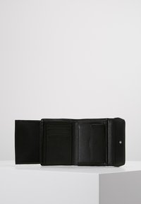 Zwarte leren portemonnee opent om meerdere kaartsleuven en een doorzichtige ID-pocket te tonen, met een gestructureerde oppervlakte en een drukknoopsluiting.