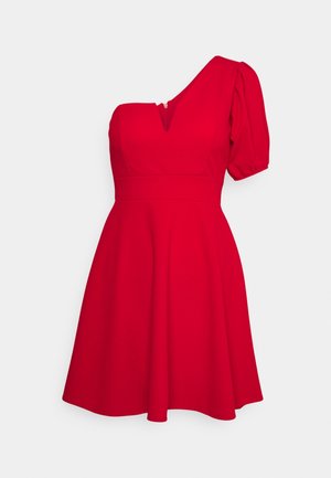 Robe rouge longueur genou avec une manche courte bouffante, une épaule dénudée, une taille cintrée et un décolleté en V avec une petite encoche.