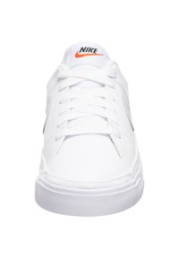 Nike sneakers dalam bahan sintetik putih, dengan bentuk ujung membulat, kerah empuk, tali datar, dan logo hitam dan oranye di lidah sepatu.