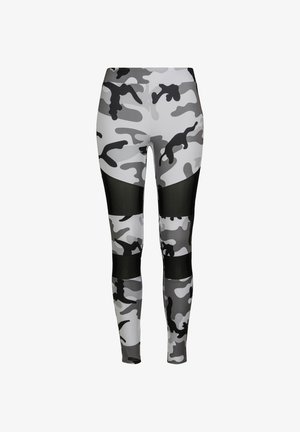 Leggings camouflage en gris et noir. Présentent un tissu extensible lisse, un design ajusté et des panneaux en résille noire transparente.