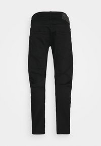 Jean noir slim-fit vu de dos avec deux poches arrière et un patch de marque sur la ceinture.