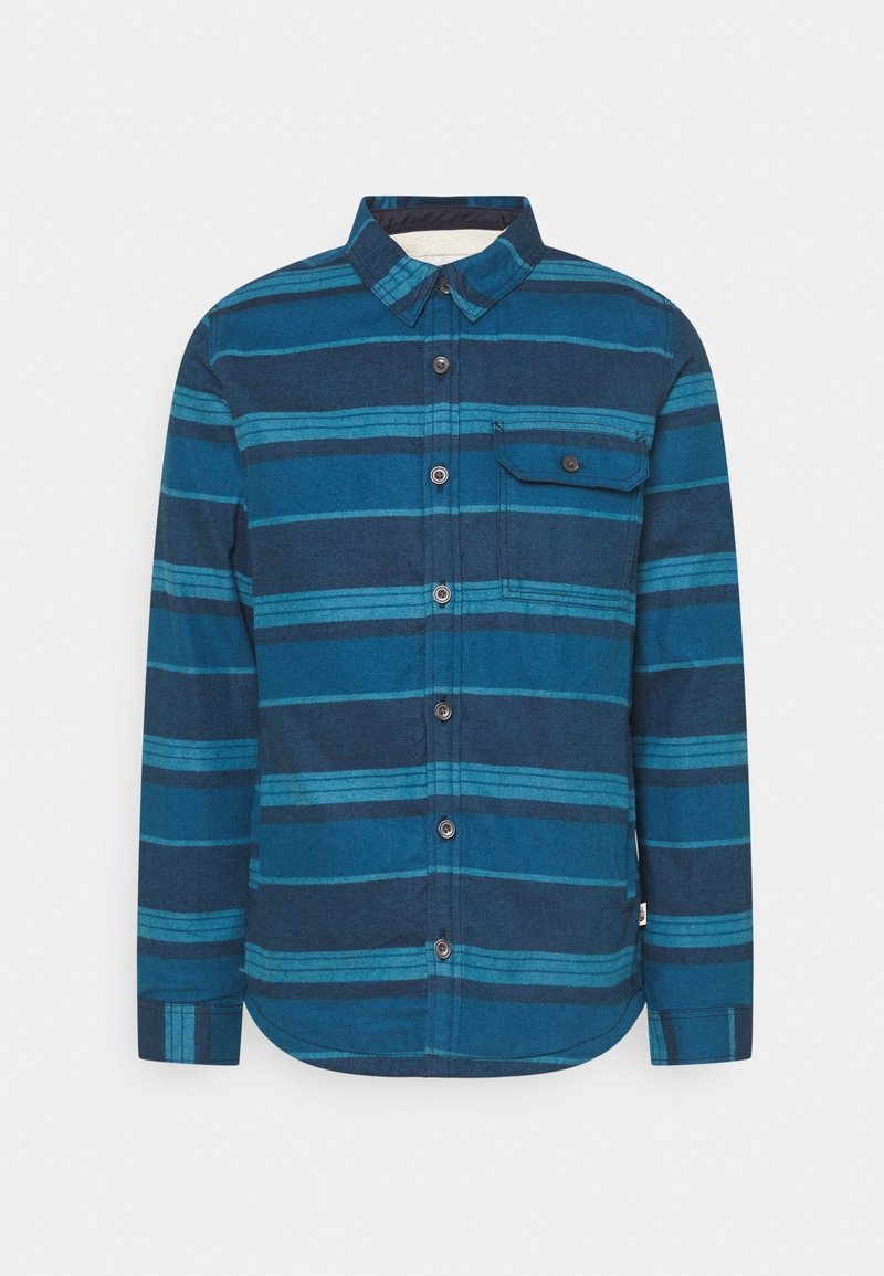 Long-sleeve button-up shirt in various shades of blue, featuring horizontal stripes, a chest pocket, and a rounded hem. Textured fabric.