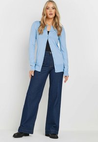 Lichtblauwe lange mouwen cardigan met knoopsluiting, gecombineerd met donkere denim wijde broekspijpen. Glad textuur, casual pasvorm en rechte silhouet.