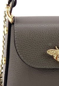Zwarte textuur lederen handtas met gouden hardware en een vlinderaccent op de klep. Voorzien van een kettingriem voor veelzijdige draagmogelijkheden.