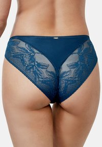 Culotte bleu marine avec des panneaux en dentelle à motifs floraux, tissu texturé et un petit accent métallique sur la taille.