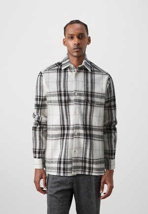 Plaid shirt in soft fabric; features large black and gray checks on a white background, with a button-up front and standard collar.