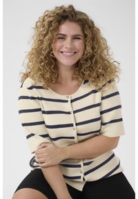 Beige strikket cardigan med marineblå vandrette striber, korte ærmer og knapper foran. Blød tekstur med ribstrikkede detaljer.