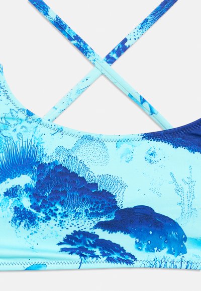 Μπλε μπικίνι με λεπτούς σταυρωτούς ιμάντες στους ώμους και αφηρημένο σχέδιο εμπνευσμένο από τη θάλασσα.