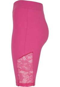 Leggings de algodón rosa con un panel de encaje en el lado inferior, textura suave y cinturilla de altura media, diseñados para comodidad y transpirabilidad.