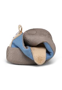 Chaussure bébé souple avec semelle en caoutchouc texturé, tige en tissu bleu, bride en daim beige et languette de traction, pliée pour montrer la flexibilité et le design antidérapant.