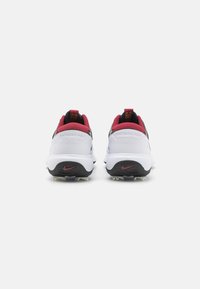 Baldos, sportiniai batai su raudonais ir juodais akcentais, turintys tekstūruotą viršutinę dalį, apvalią formą ir ryškų Nike logotipą kulne.