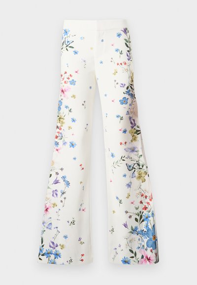 Λευκό παντελόνι με φαρδιά γραμμή και πολύχρωμο σχέδιο με λουλούδια και πεταλούδες διασκορπισμένο στο ύφασμα, απλωμένο επίπεδα σε λευκό φόντο.