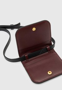 Portafoglio in pelle bordeaux con dettagli neri e chiusura a scatto dorata. Dotato di una lunga tracolla e di numerose fessure per carte all'interno.